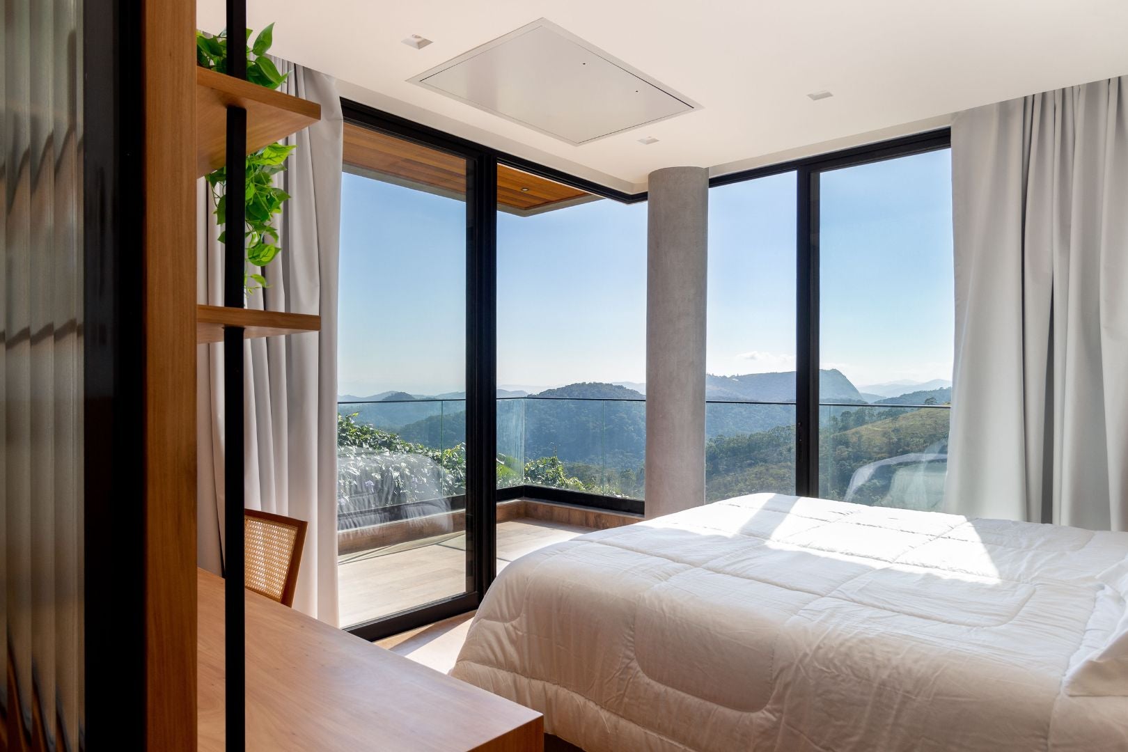 Suíte principal: cama voltada para a linda paisagem e esquadrias piso-teto