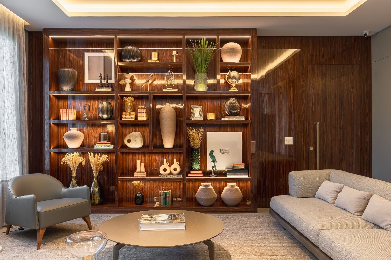 Estante do living exibe objetos que refletem as preferências dos moradores